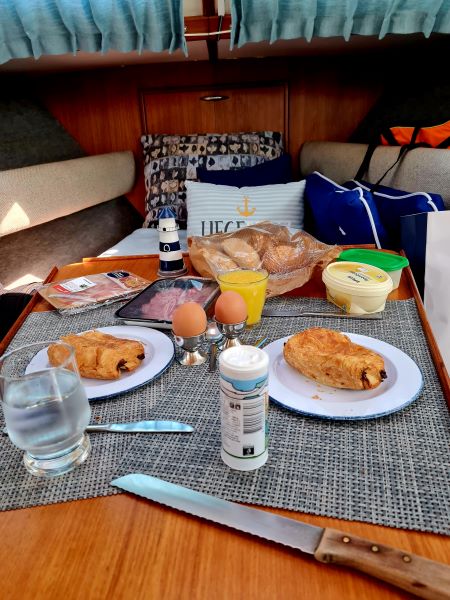 Frühstückstisch in Kombüse an Bord ist gedeckt , Croissants, Orangensaft, Eier.