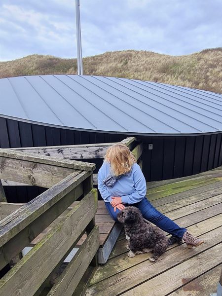 Britta Langhoff Autorin sitzt mit ihrem Hund auf einer Stufe und schaut, In welche Richtung geht es