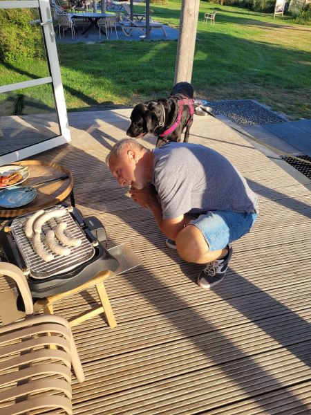 Hund und Herrchen passen auf Grillwürstchen auf